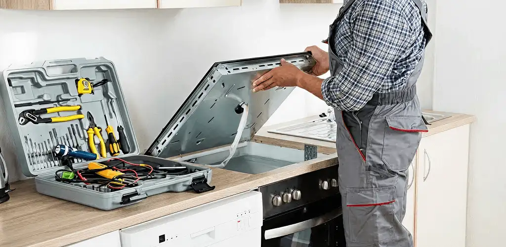 Handyman repairing a cooktop and checking wiring connections in Hollywood, FL