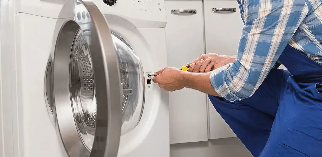 Handyman repairing a clothes dryer and checking electrical connections in Hollywood, FL