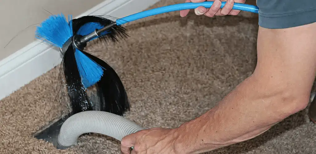 Dryer vent cleaning technician brushing lint from a vent line in Hollywood, FL