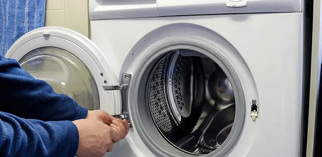 Washing machine repair handyman checking a front-load washer door and latch in Hollywood, FL
