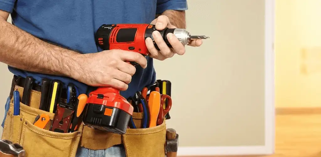 Handyman holding a power drill for home repairs and installations in Hollywood, FL