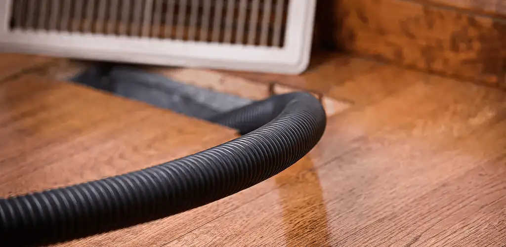 Air duct cleaning hose inserted into a floor vent for ductwork cleaning in Hollywood, FL
